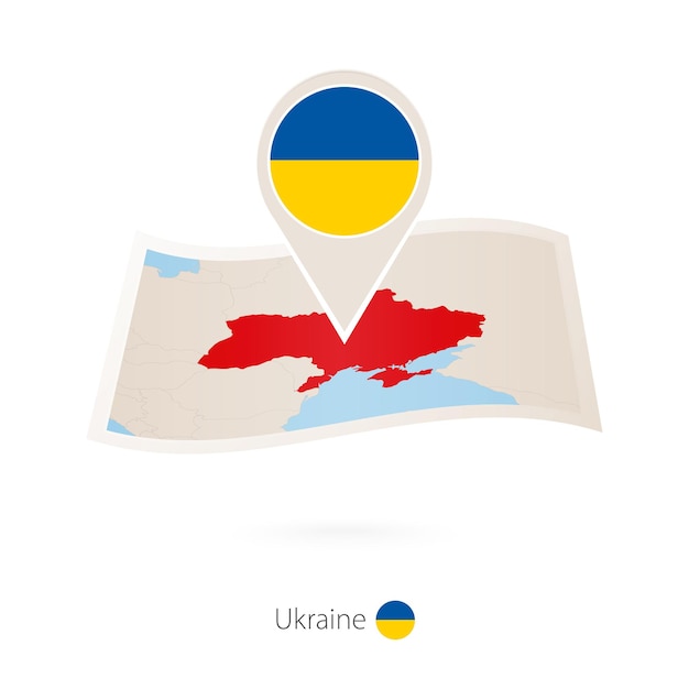 Folded paper map of Ukraine with flag pin of Ukraine