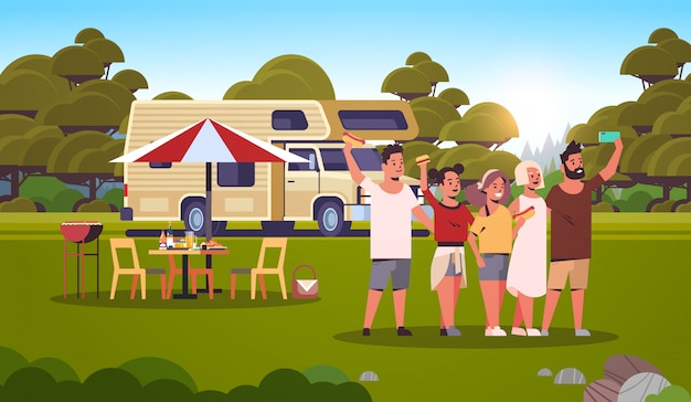 friends taking selfie photo standing at trailer outdoors happy men women group having fun summer picnic barbecue party weekend concept landscape background flat full length horizontal