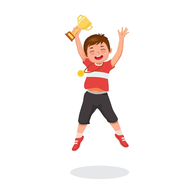 Gelukkig jongetje met medaille springen terwijl hij een bekertrofee vasthoudt die de winnende competitieprijs viert