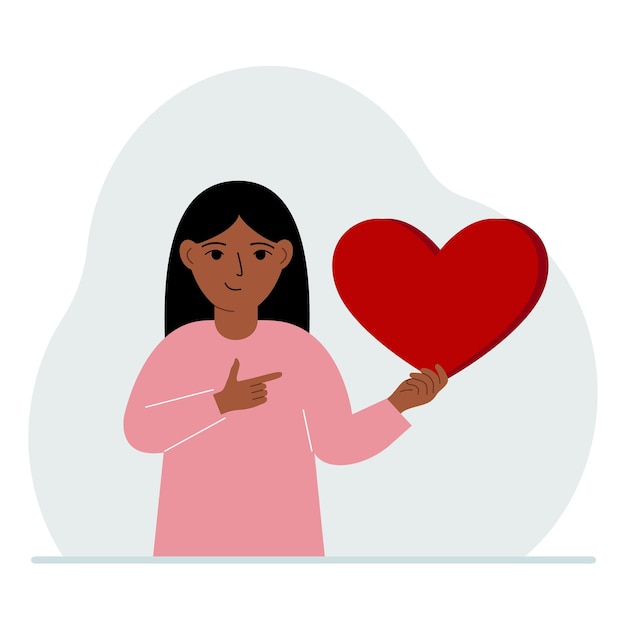 A girl holds a big red heart in his hand the concept of volunteering romantic relationship or love