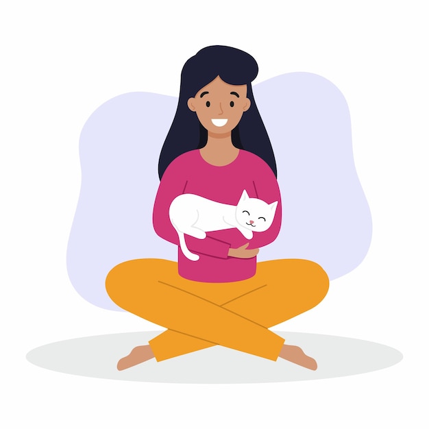 A girl holds a cat in her arms. a woman with a cat is sitting on the floor. owner and pet.