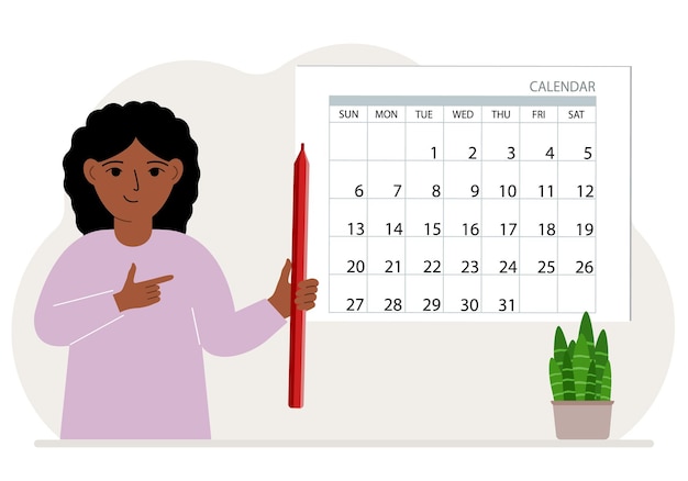 The girl holds a red pencil and stands near a large calendar