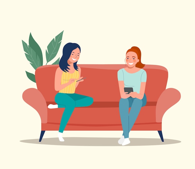 Girlfriends are sitting on the sofa with smartphones