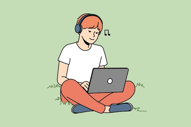 Guy sitting on grass with laptop and headphones