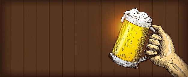 木製の背景にビールのグラスを持っている手の手書き