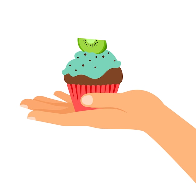 Hand holding cupcake with kiwi