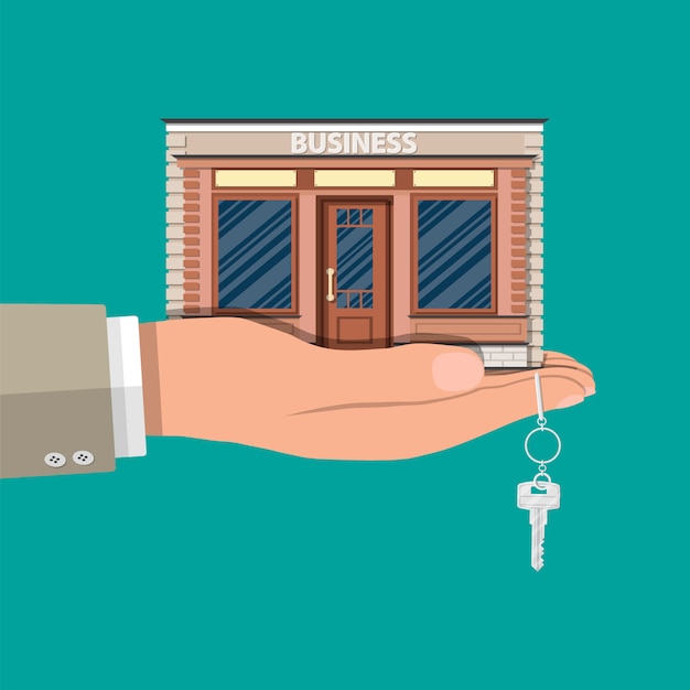 Hand holding shop or commercial property with key.