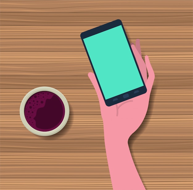 hand using smartphone with coffee cup in the table