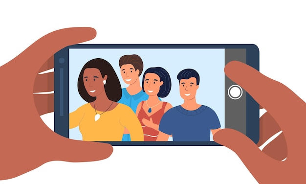 Hands holding smartphone with young smiling men and women taking selfie