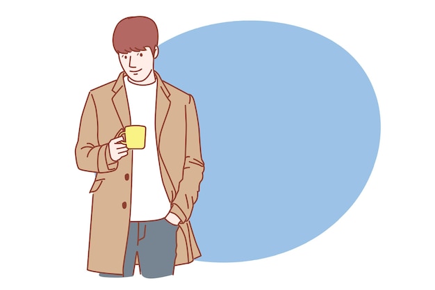 행복 하 게 커피를 마시는 코트를 입고 잘생긴 젊은 남자.