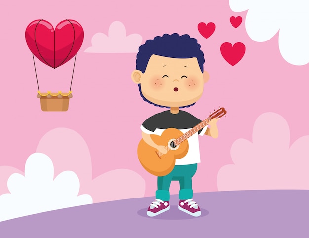 Happy boy playing guitar and singing over hot air balloon with heart shape
