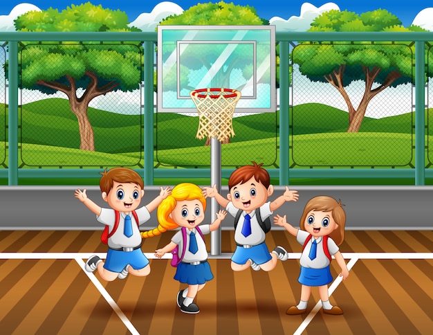 Happy children in uniform at jumping at the basketball court