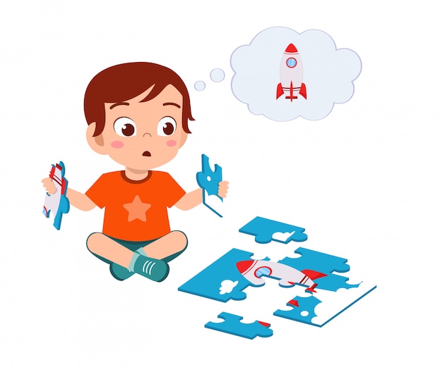 Happy cute little kid boy play jigsaw puzzle