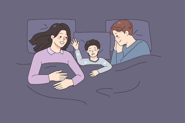 Famiglia felice con il bambino che dorme nel letto