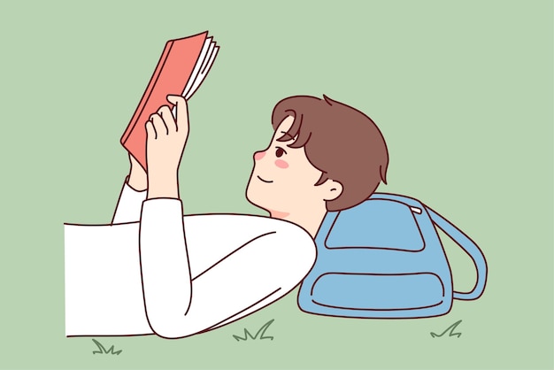 Happy guy lying on ground reading book