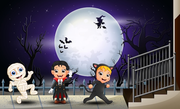 Bambini felici halloween sullo sfondo di luna piena