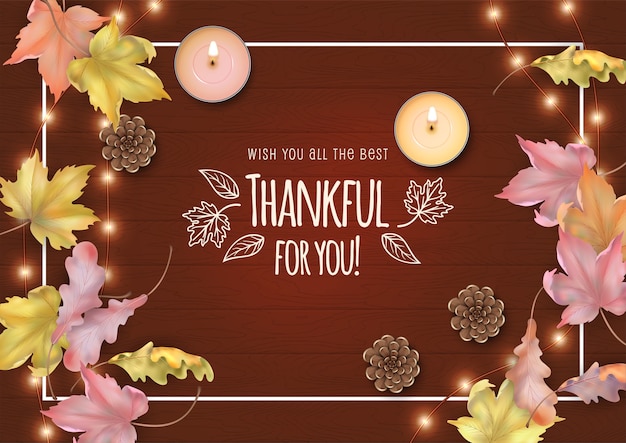 Happy thanksgiving card with fallen leaves, candles and cones on a wooden background