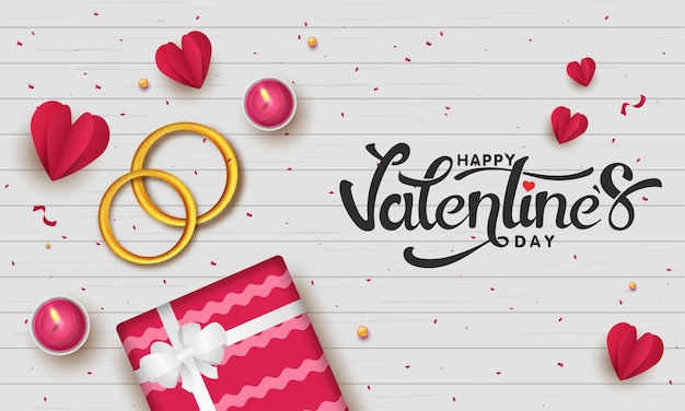 Happy Valentine's Day lettertype met bovenaanzicht van gouden paar ringen, geschenkdoos, papier gesneden harten en verlichte thee kaarsen op witte houten textuur achtergrond.