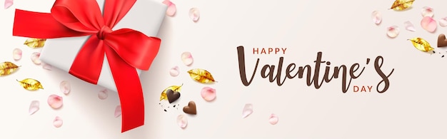 Felice banner romantico di san valentino. scatola regalo bianca e fiocco rosso, foglie dorate, forma di cuore di cioccolato, petali di rosa rosa.