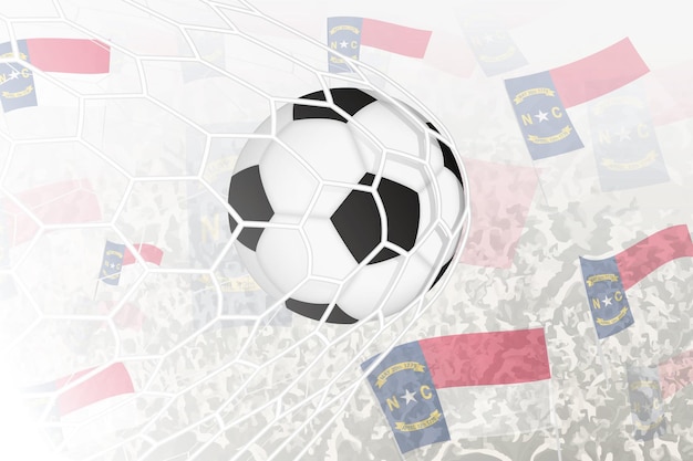 Het nationale voetbalteam van North Carolina scoorde een doelpunt Ball in het doelnet terwijl voetbalondersteuners de vlag van North Carolina op de achtergrond zwaaien