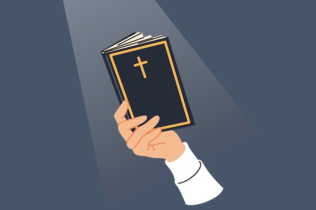 聖書は男の手で祈りと戒めを読みカバーにキリスト教の十字架があります