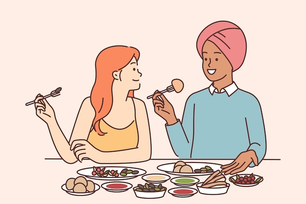 Indian man and caucasian woman are sitting at dinner table tasting traditional Indian cuisine