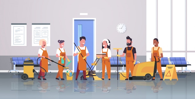 Janitors team cleaning service male female cleaners in uniform working together with professional equipment modern corridor interior