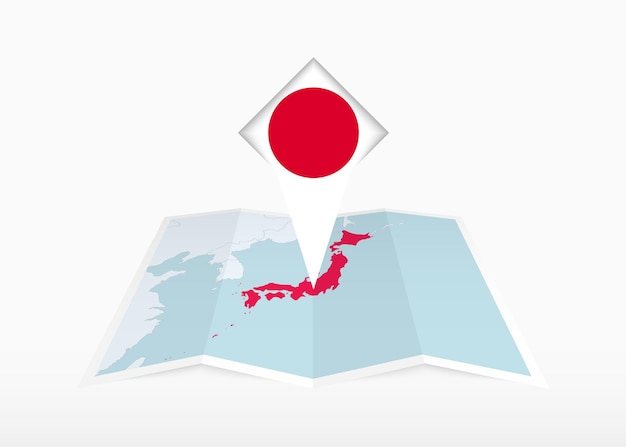 Japan is afgebeeld op een gevouwen papieren kaart met een plaatsmarkering met de vlag van Japan.