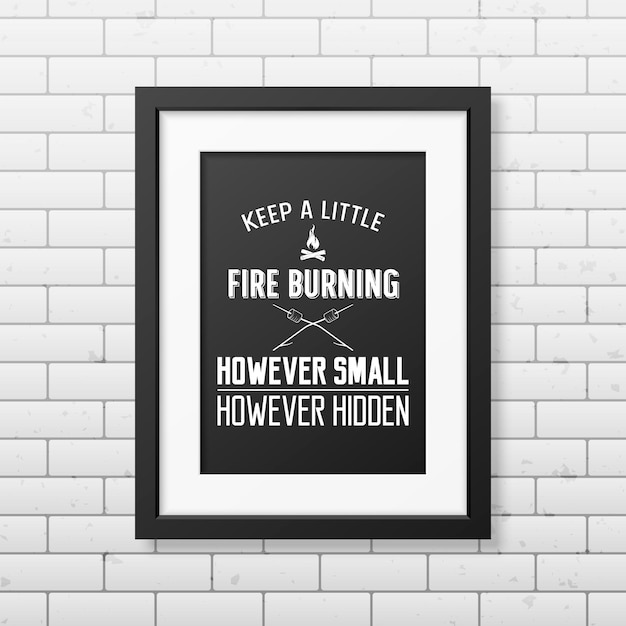 Keep a little fire burning however small however hidden - quote typographical background in the realistic square black frame on the brick wall background.