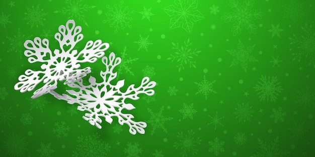 Kerstachtergrond met twee gebogen papieren sneeuwvlokken met zachte schaduwen op groene achtergrond
