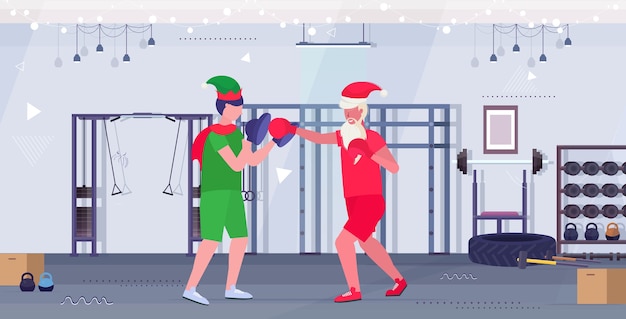 Kerstman bokser beoefenen van boksoefeningen met elf helper training gezonde levensstijl kerstvakantie viering concept moderne sportschool interieur