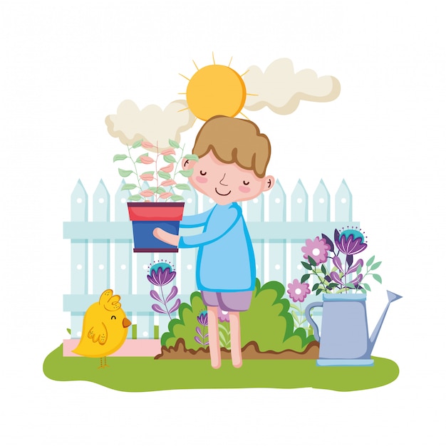 Маленький мальчик поднимая комнатное растение с забором и цыпленок