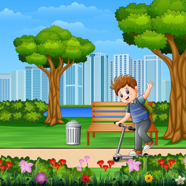 Маленький мальчик на скутере в парке города