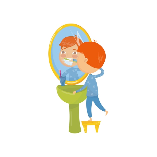 Little boy standing on chair in front of bathroom sink and brushing his teeth Dental care Daily morning and evening routine Kid in blue pajamas Flat vector design