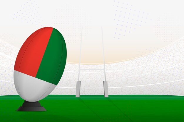 Vettore pallone da rugby della squadra nazionale del madagascar sullo stadio di rugby e sui pali della porta che si preparano per un rigore o un calcio di punizione