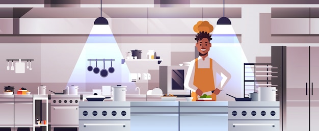 Vettore cuoco professionista maschio cuoco tagliare le verdure a pezzi sul bordo di intaglio uomo afroamericano in uniforme che prepara insalata che cucina ritratto moderno dell'interiore della cucina del ristorante di concetto dell'alimento