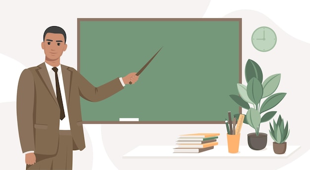 Male teacher standing by blackboard in the classroom. Concept of education and training.