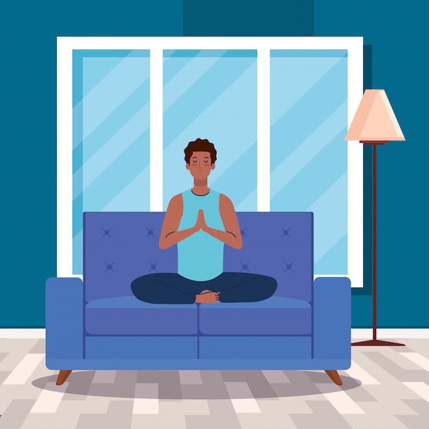 man afro meditating in the living room, sitting in couch