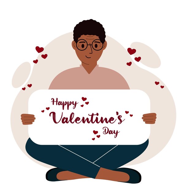 A man sits crosslegged and holds a large card with a congratulation for saint valentine