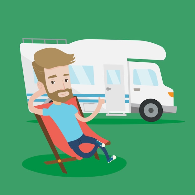 Man sitting in chair in front of camper van.