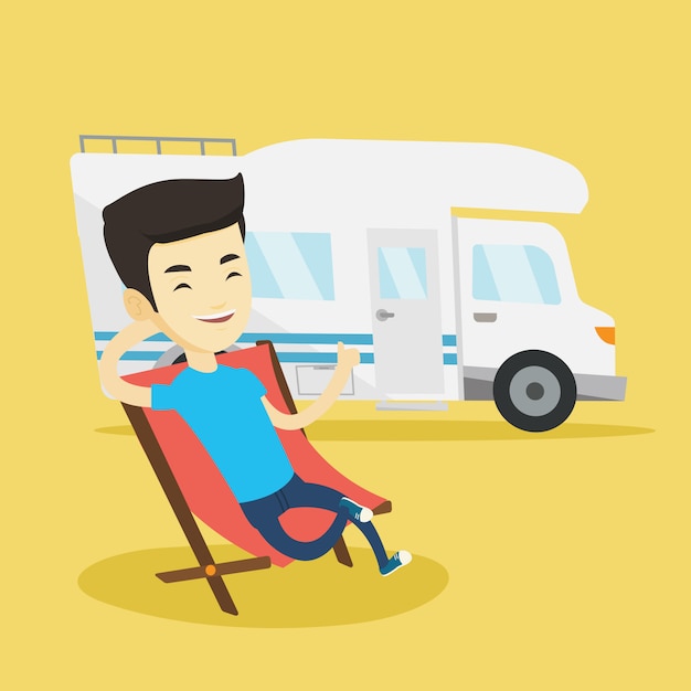 Man sitting in chair in front of camper van.