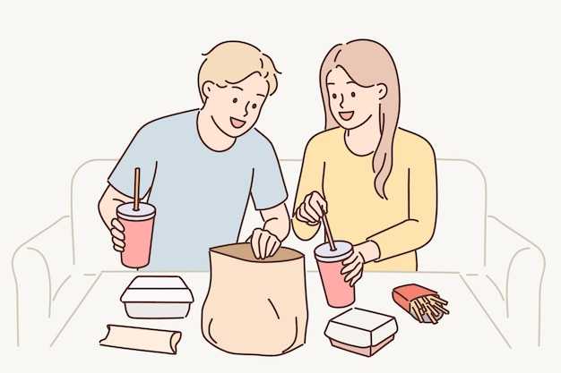 Man and woman have lunch sitting at table enjoy takeout food delivered by courier from restaurant