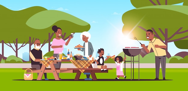 Multi-generatie familie hotdogs op grill picknick barbecue partij concept zomer park landschap achtergrond vlakke volledige lengte horizontale voorbereiding