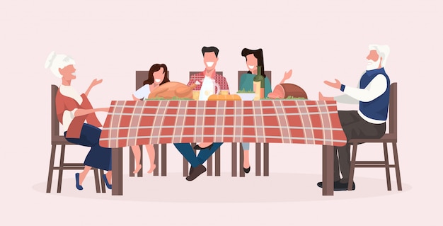 multi generatie familie zittend aan tafel met kerst diner