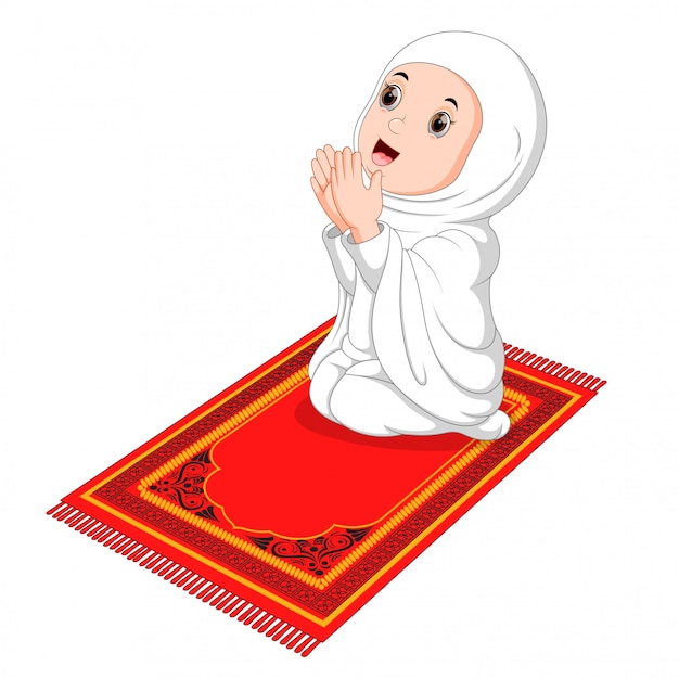 Muslim girl sitting on the prayer rug while praying