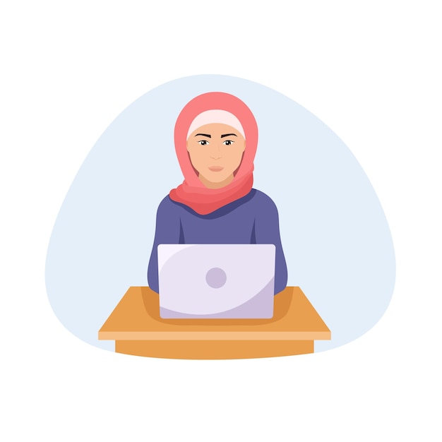 Muslim woman wearing traditional clothing sitting at the table with laptop