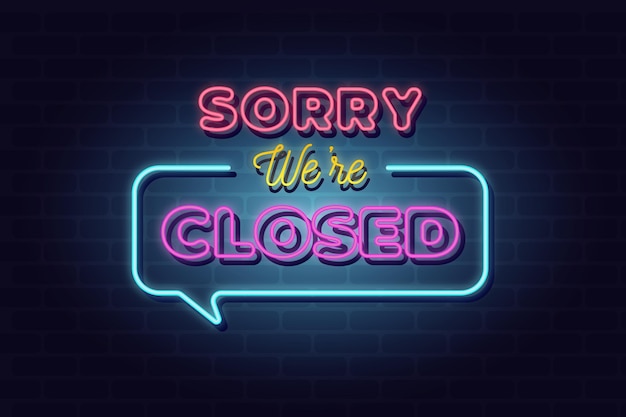 Neon 'sorry we are closed' sign on brick wall