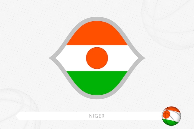 灰色のバスケットボールの背景にバスケットボールの競争のためのニジェールの旗。