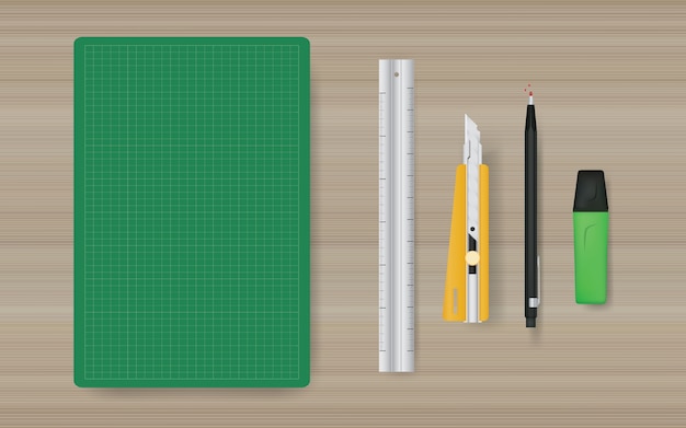 Office object background of green cutting mat with ruler, cutter, pencil and marker