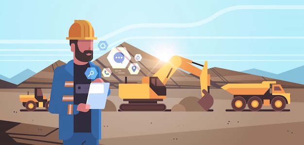 open pit man werknemer in helm met behulp van mobiele app graafmachine